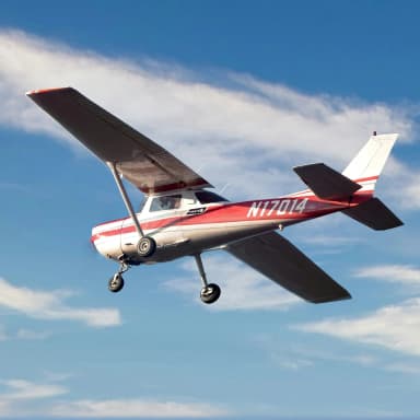 photo of a Cessna 150 with a clear blue sky in background